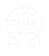 White badge graphic with $500M+ in large text at the center, symbolizing an achievement or milestone; details and border are faint and hard to see against the light background.